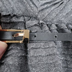 Close-up of the black belt and gold-tone buckle
