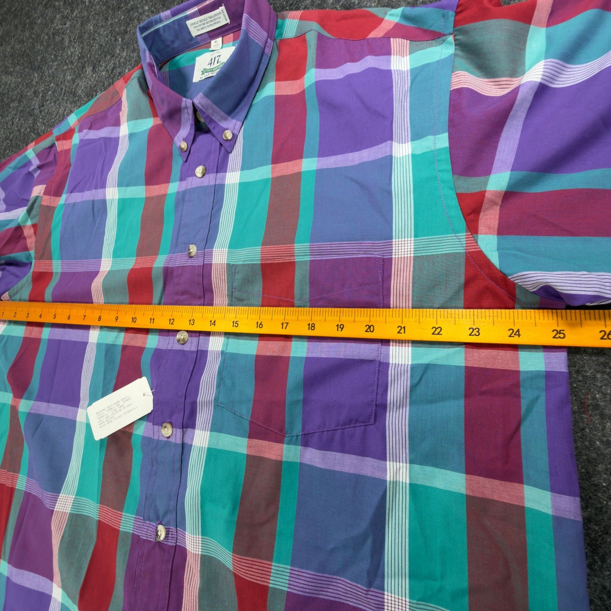 Purple, turquoise and red plaid 417 by Van Heusen shirt, chest laid flat with ruler across width