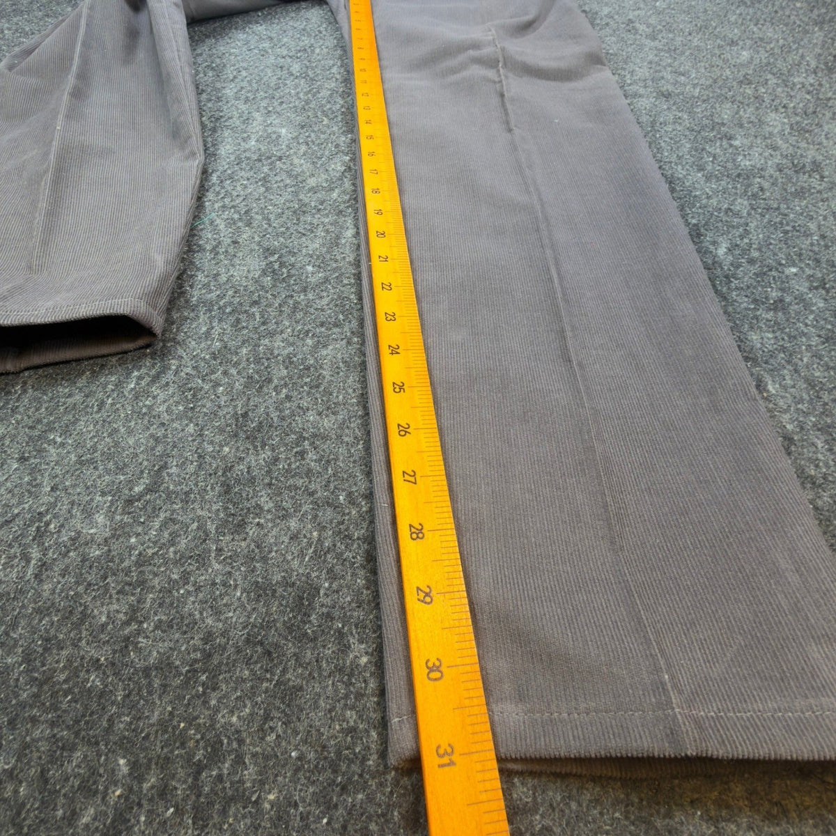 Ruler alongside the inner leg of gray Lee Casuals pleated corduroy trousers
