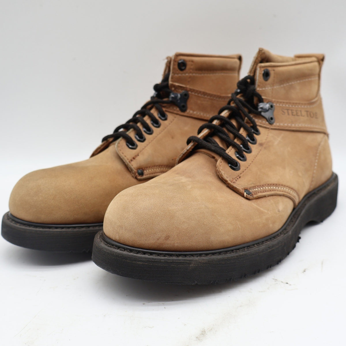 Three-quarter view of tan Carolina ankle boots with black laces with toes pointing left
