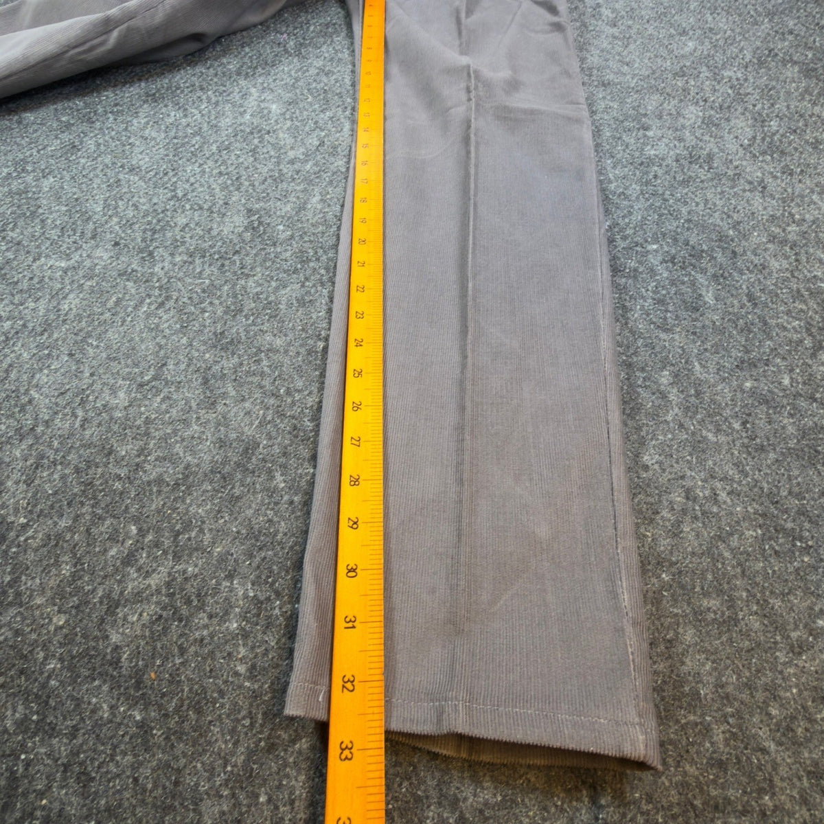 Ruler alongside the inner leg of gray Lee Casuals pleated corduroy trousers
