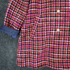 Pink, orange and navy AURA plaid double-breasted coat, close-up of lower front, buttons and turned-back cuff